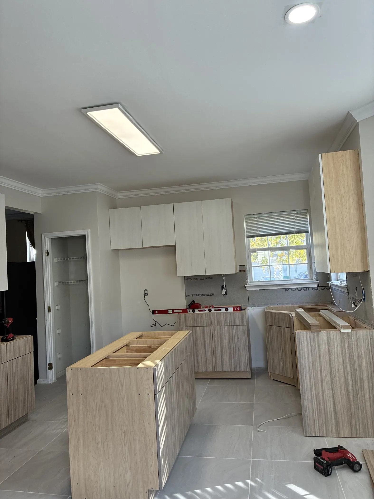 Kitchen with new cabinetry installed and open lower cabinet bases awaiting countertops.