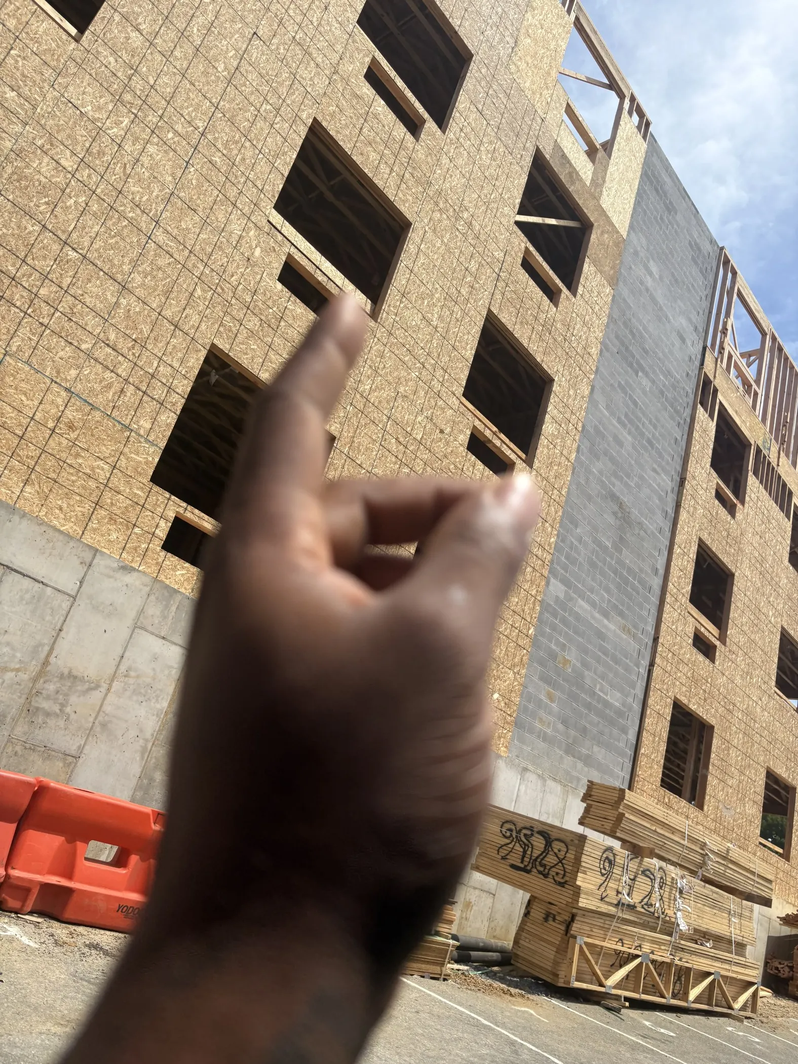 Wall sheathing, open window bays and exposed upper framing on a multistorey building.